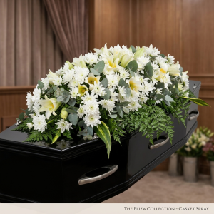 Large white coffin spray funeral flowers with white roses, lilies, and sprays
